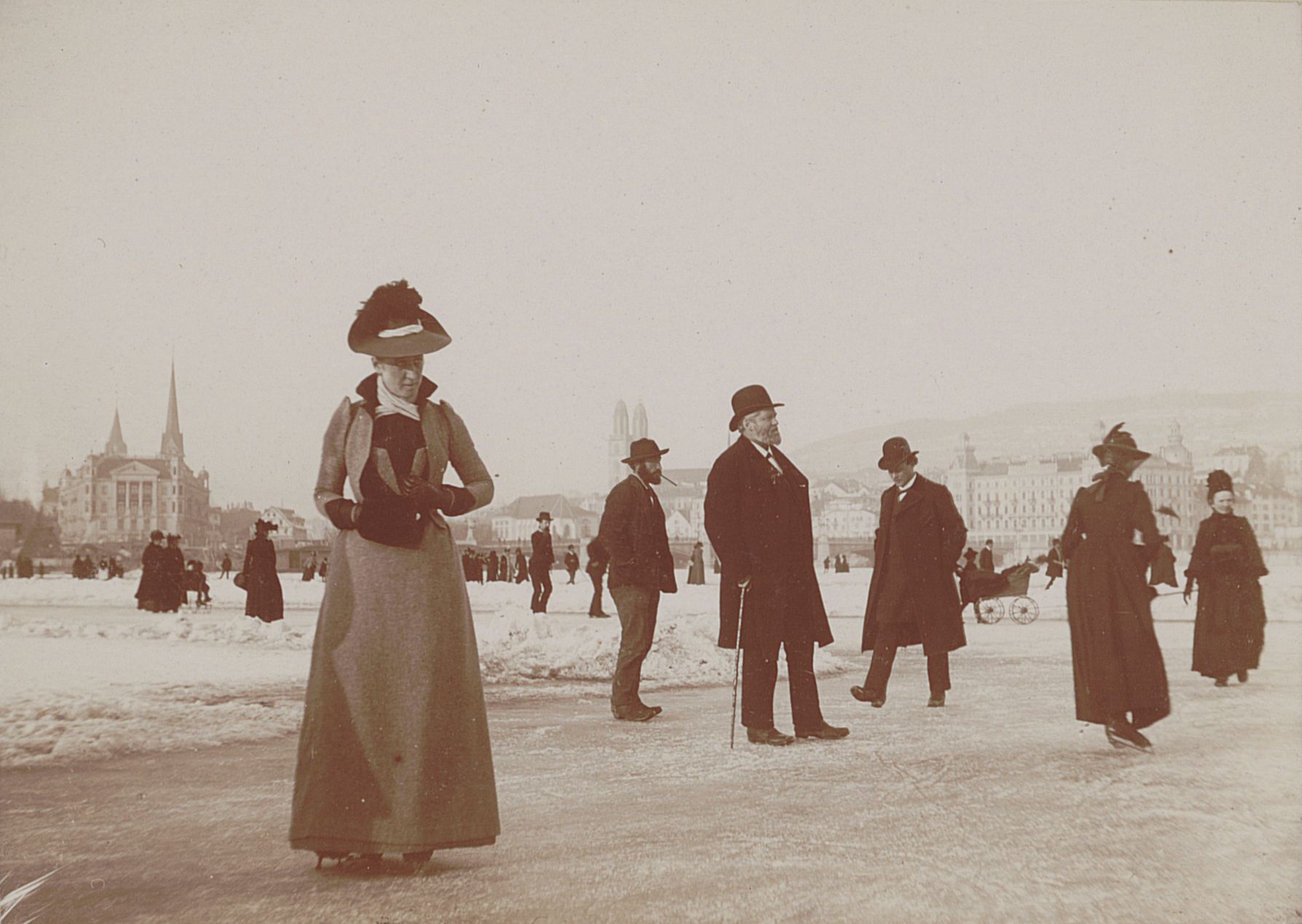 Schulpräsident Hirzel (in der Bildmitte) samt Spaziergängern und Schlittschuhläufern auf dem gefrorenen Zürichsee im Jahr 1891. Fotografie, Silbergelatineabzug, 8,1 x 11,4 cm. 