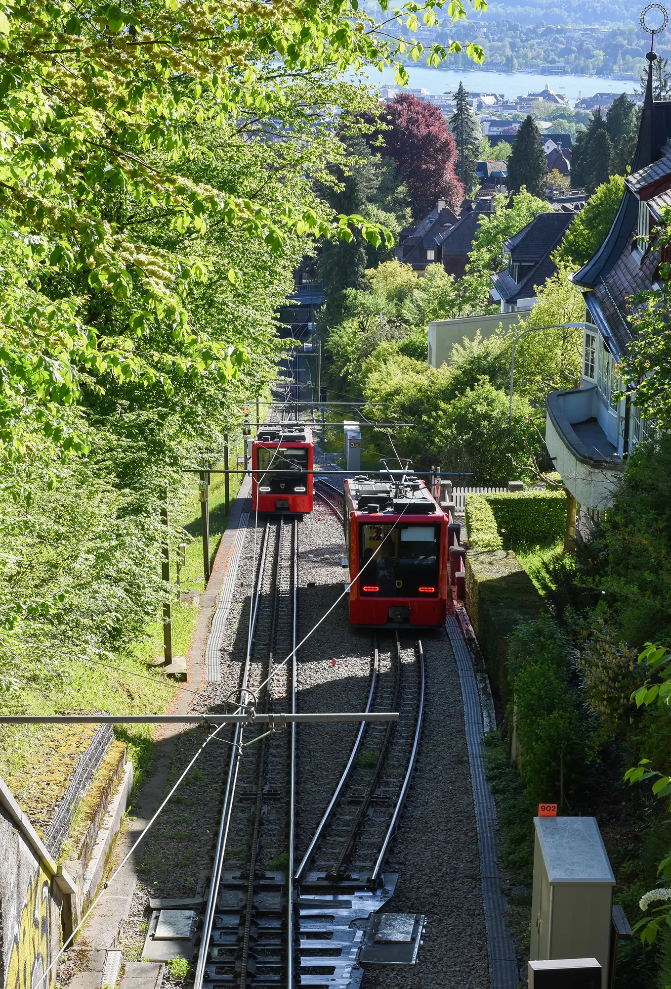 Die zwei Fahrzeuge der Dolderbahn kreuzen sich bei der Ausweichstelle unterhalb der Bahnüberquerung bei der Aurorastrasse im April 2026. (Bild: Aufnahme der Autorinnen)