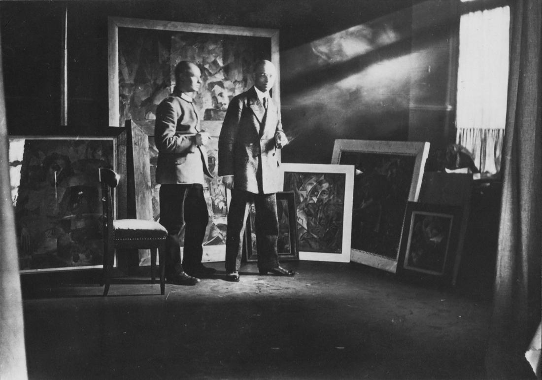Johannes Itten in seinem Atelier zusammen mit Oskar Schlemmer, Stuttgart 1913, im Bildhintergrund seine frühen abstrakten Gemälde