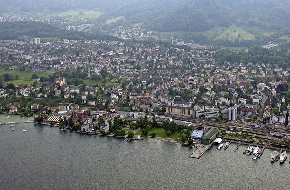 Eine Luftaufnahme von Wollishofen mit der Roten Fabrik, dem Gemeinschaftszentrum und der Werft. Im Hintergrund Leimbach  <br />(Bild: Juliet Haller / Baugeschichtliches Archiv der Stadt Zürich)