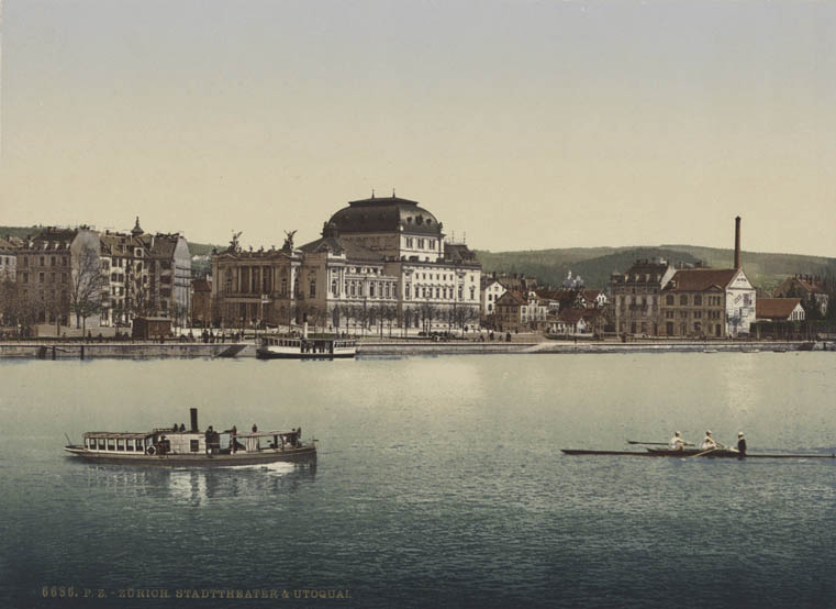ZürichFenster, Zürcher Kulturleben 1918, Photochromdruck mit Blick von der Quaibrücke auf das Züricher Stadttheater und das Utoquai zwischen 1891 und 1914, im Vordergrund ein Dampfschiff und ein Ruderboot.